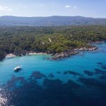 aegean-sea-coast-with-blue-transparent-water-ship-greenery-around-rocks-bushes-trees-view-from-drone-greece~1 (1)