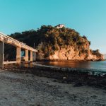 beach-surrounded-by-sea-rocks-covered-greenery-with-bridge-brazil~1 (1)